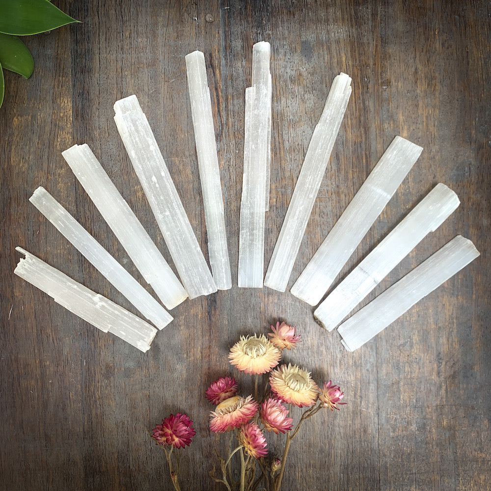 Selenite sticks fanned across table with flowers