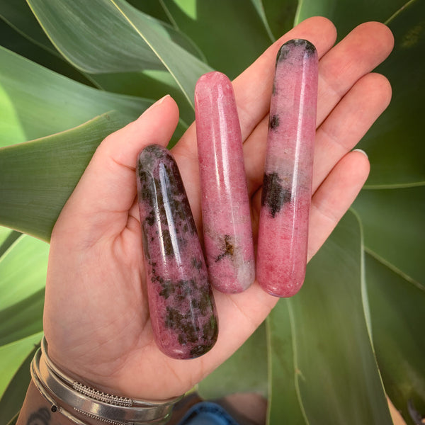 rhodonite massage wands held in palm of hand