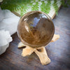 Smokey quartz crystal ball on wooden stand